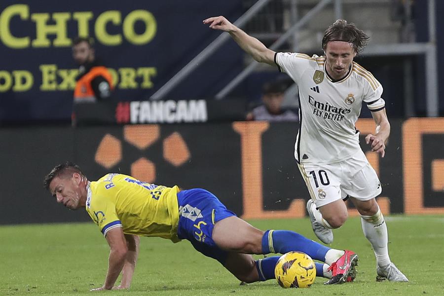 El centrocampista croata del Real Madrid Luka Modric (d) lucha con Raúl Alcaraz, del Cádiz CF, durante el partido de la jornada 14 de LaLiga que enfrentó al Cádiz CF y el Real Madrid el domingo en el Estadio Nuevo Mirandilla. EFE/Román Ríos.