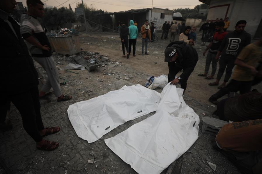 Palestinos retiran los cadáveres de víctimas mortales de un ataque aéreo israelí en la localidad de Deir al Balah, en el sur de la Franja de Gaza. EFE/EPA/Mohammed Saber