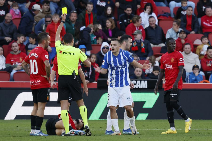 El defensa del Deportivo Alavés Andoni Gorosabel (2d) recibe una cartulina amarilla durante el partido ante el Mallorca correspondiente a la jornada 15 de LaLiga que ambos clubes disputaron en el estadio de Son Moix.- EFE/CATI CLADERA