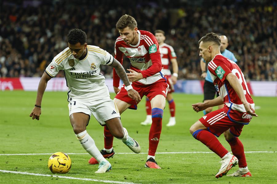  El delantero brasileño del Real Madrid Rodrygo Goes (i) disputa un balón ante Gerard Gumbau (c) centrocampista del Granada durante el partido correspondiente a la jornada 15 de LaLiga en el Santiago Bernabéu. EFE/ Mariscal

