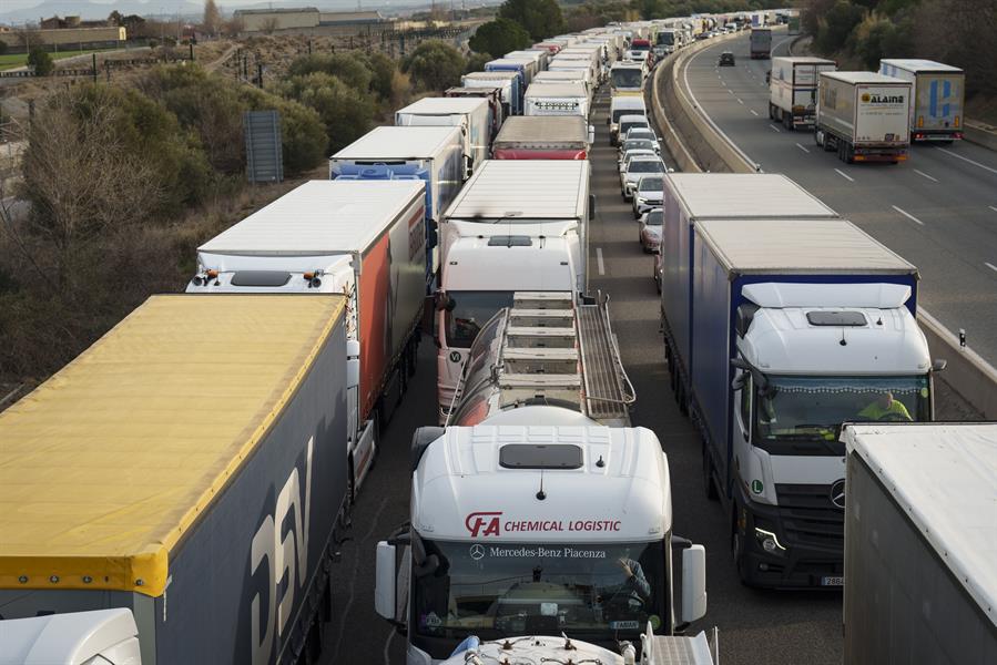 Las protestas de los agricultores franceses se han endurecido y han acabado cortando este viernes la autopista AP-7 en la Jonquera (Girona) en ambos sentidos de circulación y para todo tipo de vehículos. En la imagen agentes de los Mossos d'Esquadra informan a los camioneros que circulan por esta vía.EFE/ David Borrat