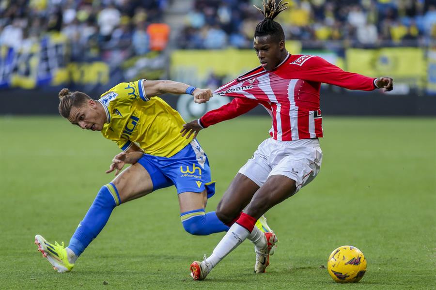 El delantero del Athletic Club de Bilbao, N. Williams lucha por el balón con el delantero del Cádiz CF Iván Alejo, durante el partido de LaLiga EA Sports, entre el Cádiz CF y el Athletic Club de Bilbao, en el estadio Nuevo Mirandillade Cádiz. EFE/ Román Ríos