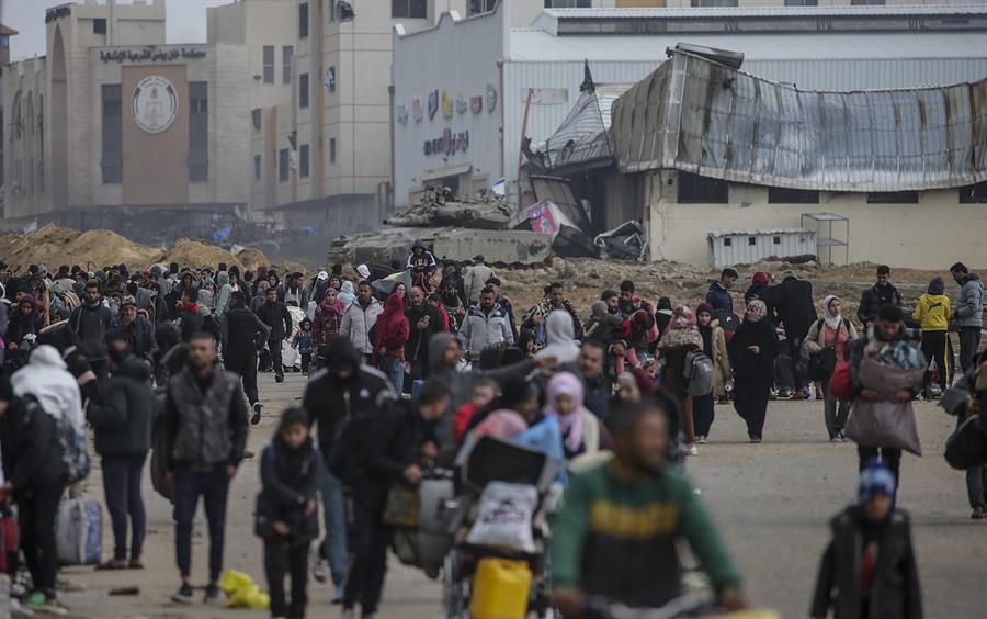 Los palestinos desplazados internos pasan junto a los tanques israelíes en el sur de la Franja de Gaza, el 27 de enero de 2024. EFE/EPA/Mohammed Saber