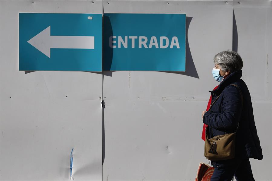 Una mujer con mascarilla camina en el entorno de un centro de salud en Madrid este lunes, día en el que el Ministerio de Sanidad ha pedido a las comunidades que implanten el uso obligatorio de la mascarilla en centros sanitarios y sociosanitarios, una medida que se aplicaría de forma transitoria mientras dure el pico epidémico de la gripe y otros virus respiratorios, y que ya han decretado Cataluña, la Comunidad Valencia y Murcia. EFE/ Rodrigo Jiménez