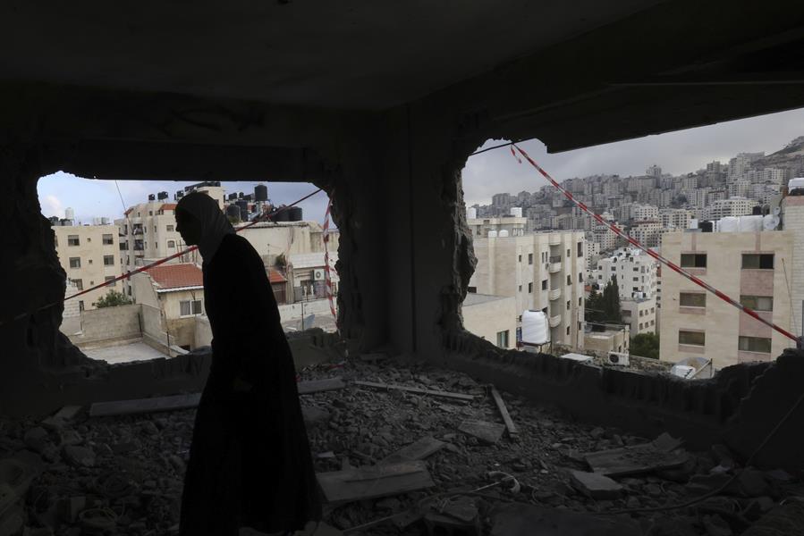 Una mujer recorre el lugar de un bombardeo en la Franja de Gaza, en una fotografía de archivo. EFE/Alaa Badarneh