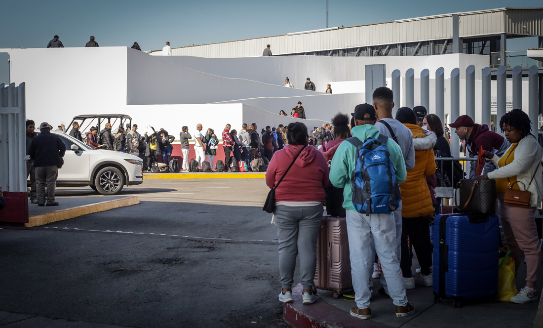 Migrantes hacen fila para solicitar un proceso de asilo en Estados Unidos, el 22 de febrero de 2024 en el paso fronterizo del Chaparral, en Baja California (México). EFE/Joebeth Terriquez
