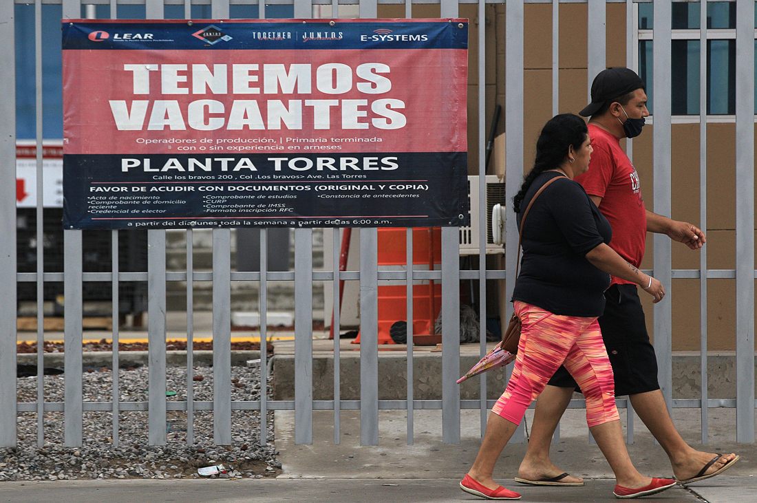 Fotografía de archivo donde se observa a personas frente a una fabrica que anuncia vacantes en Ciudad Juárez, Chihuahua (México). EFE/ Luis Torres