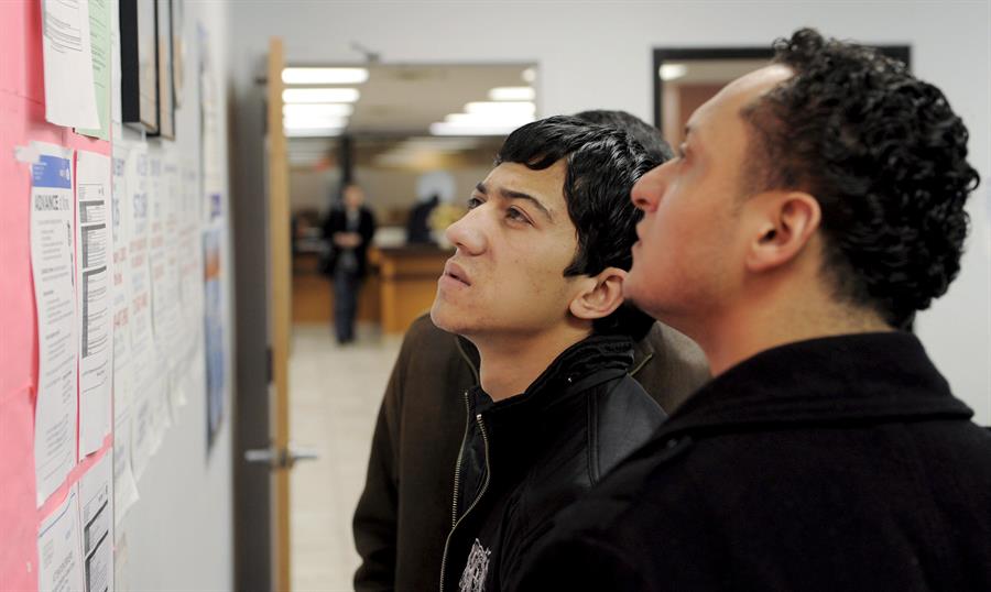 Fotografía de archivo de 2 personas que buscan trabajo en un tablón de anuncios del centro de desempleo Workforce1 Career Center en Brooklyn, Nueva York, EUA. EFE/Justin Lane