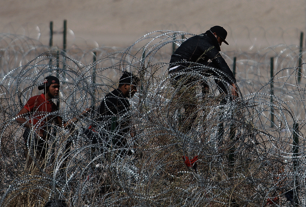 Migrantes intentan cruzar la cerca de alambres en la frontera que divide a México de los Estados Unidos, el 23 de febrero de 2024, en Ciudad Juárez (México). EFE/Luis Torres