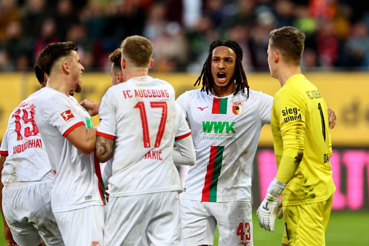 El portero del Augsburg Finn Dahmen (d) celebra con sus compañeros la detención de un penalti durante el partid FC Augsburg- RB Leipzig jugado en Augsburgo, Alemania. EFE/EPA/Anna Szilagyi