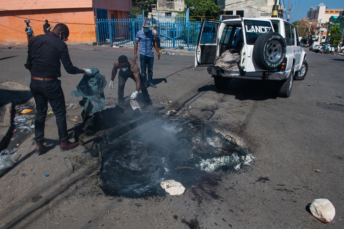 Empleados municipales recogen los restos de un cadáver carbonizado hallado en la calle en Puerto Príncipe (Haití). EFE/ Johnson Sabin