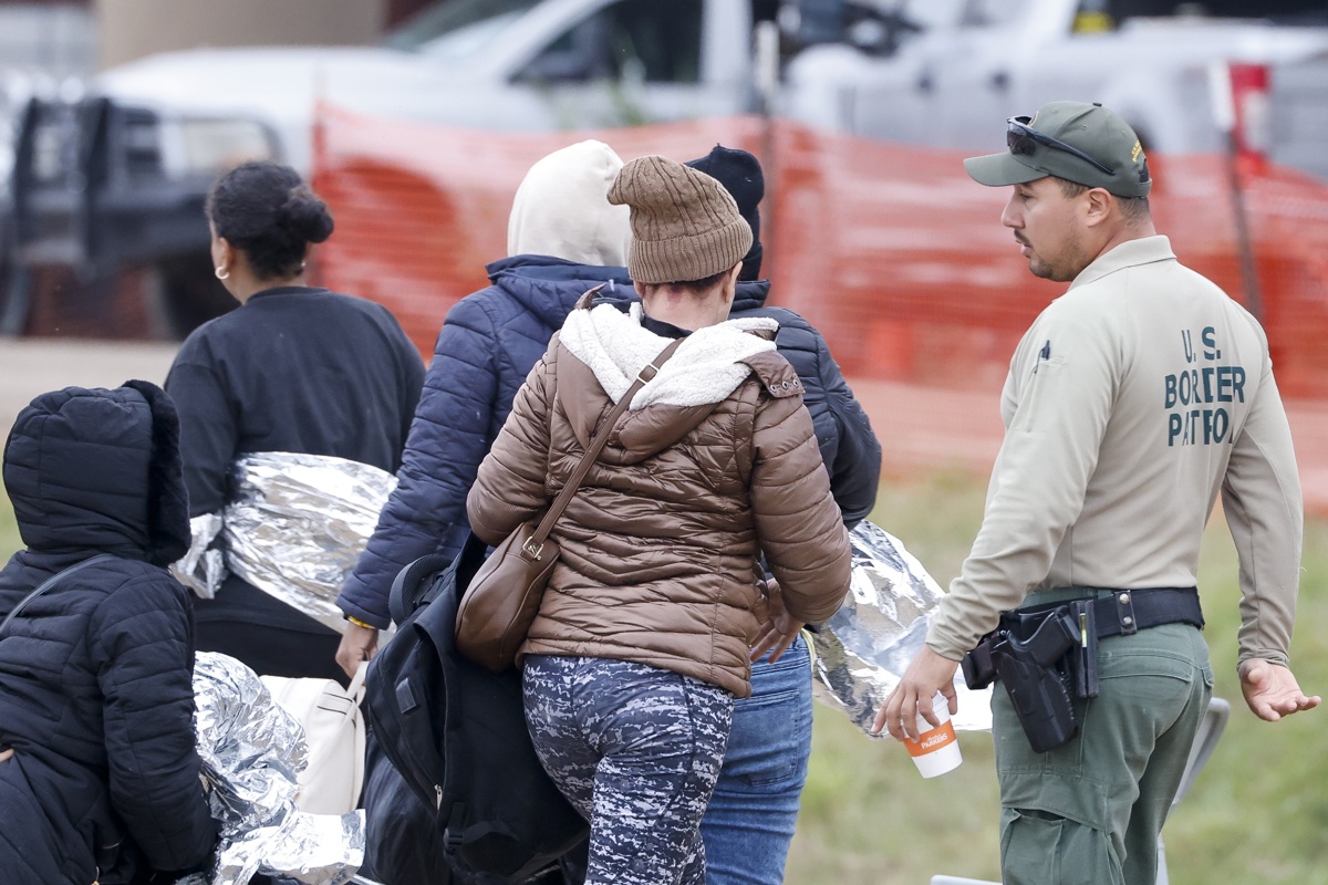 Fotografía de archivo donde se ve a un grupo de migrantes pasando junto a un guardia de la patrulla fronteriza de Estados Unidos en Eagle Pass, Texas (EUA). EFE/EPA/Adam Davis