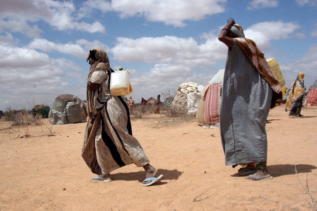 En la imagen de archivo, unas mujeres transportan agua hasta sus improvisados barracones en las afueras de Wajir, unos 1,400 kilómetros al norte de Nairobi (Kenia). EFE/Stephen Morrison