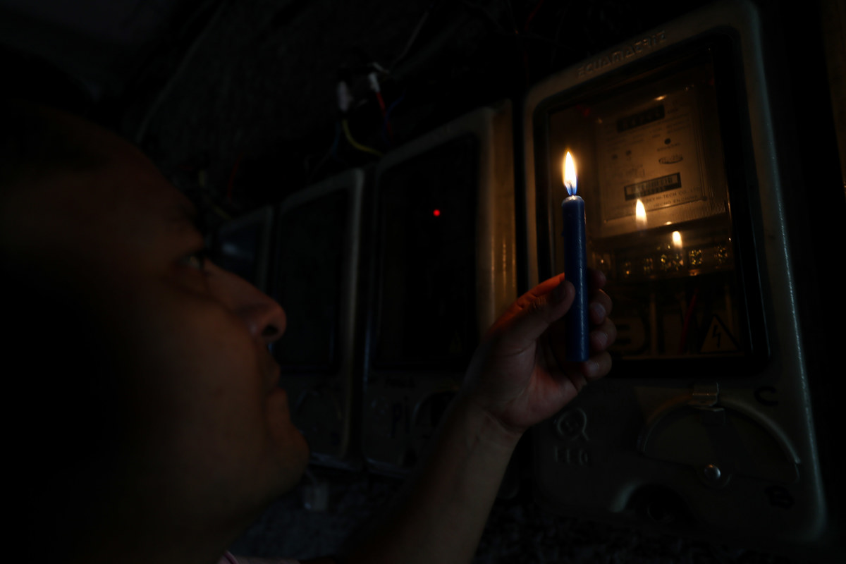 Un ciudadano ecuatoriano revisa un medidor de luz en Quito (Ecuador). EFE/ José Jácome