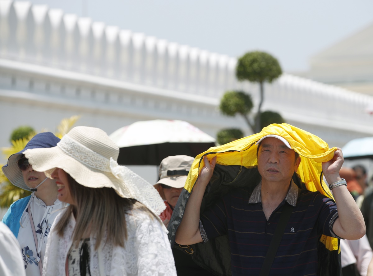 Un grupo de turistas se protege del sol en el Gran Palacio de Bangkok en medio de la fuerte ola de calor que golpea Tailandia y el sureste de Asia. EFE/EPA/RUNGROJ YONGRIT