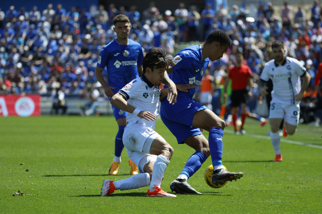 El delantero británico del Getafe Mason Greenwood (d) disputa un balón ante el centrocampista japonés de la Real Sociedad Take Kubo (i) durante el partido de la jornada 32 que enfrentó al Getafe FC y a la Real Sociedad, este domingo, en Getafe (Madrid). EFE/Zipi