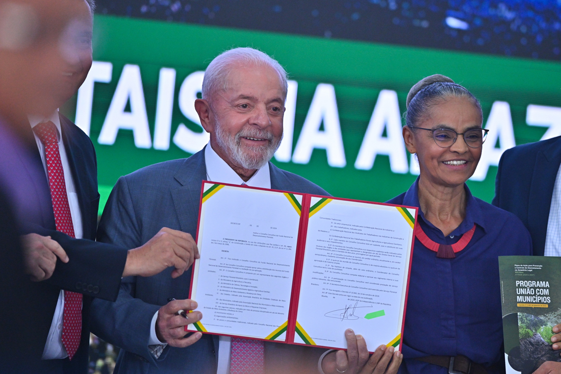 El presidente de Brasil, Luiz Inácio Lula da Silva, junto de la ministra de Medio Ambiente, Marina Silva, sostiene un documento durante el lanzamiento del programa Unión con Municipios, por la reducción de la deforestación y los incendios forestales en la Amazonía este martes, en el Palácio del Planalto en Brasilia (Brasil). EFE/Andre Borges