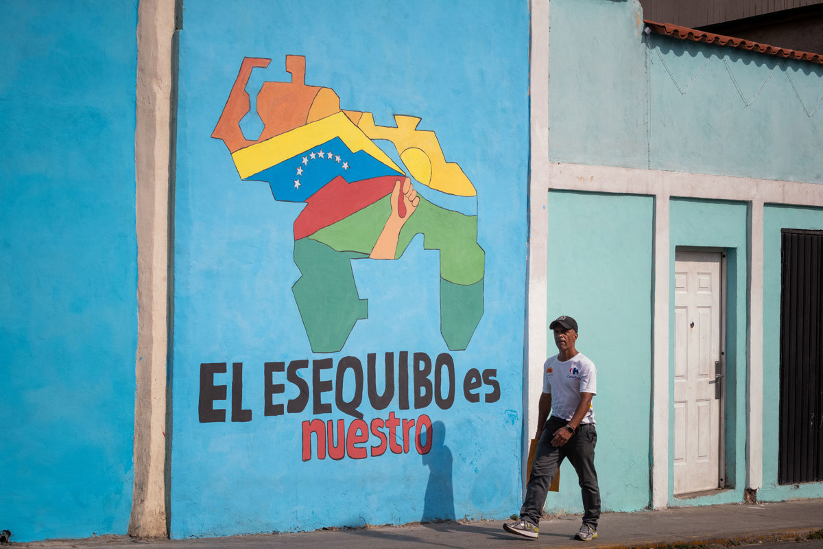 Foto de archivo de un transeúnte frente a un mural con el mapa de Venezuela que dice “El Esequibo es nuestro”, en Caracas (Venezuela). EFE/ Rayner Peña R.