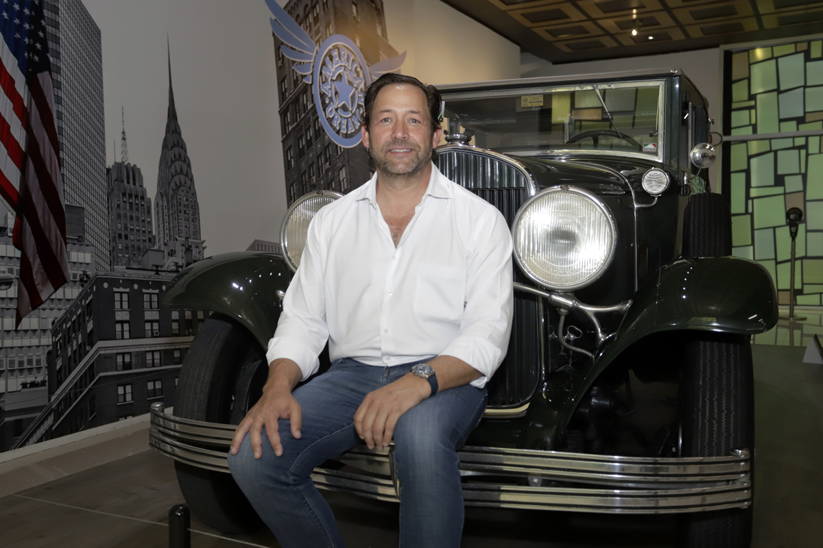 Gerardo Jean Carrasco posa junto a un automóvil Chrysler 1929, serie 75 Custom Convertible Sedán, en la ciudad de Puebla (México). EFE/ Hilda Ríos