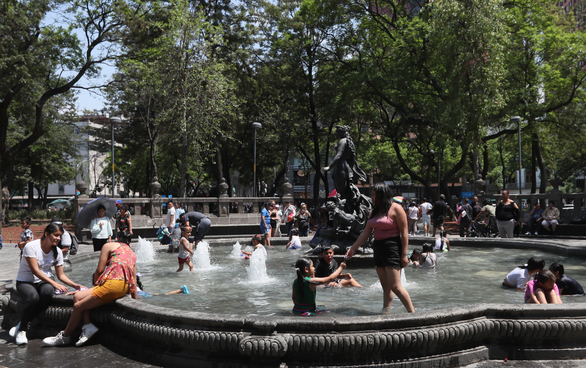 Personas se refrescan en una fuente debido a las altas temperaturas registradas en la Ciudad de México (México). EFE/Mario Guzmán