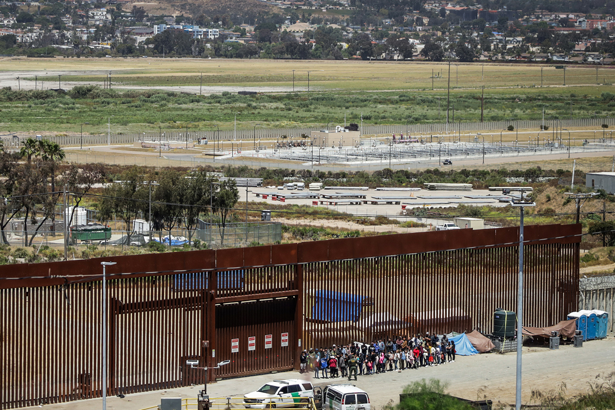 Migrantes permanecen en la línea divisoria entre México y EUA en Tijuana (México). EFE/ Joebeth Terriquez