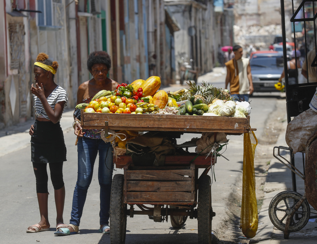 Foto de una mujer (2i) que observa los productos agrícolas de un vendedor ambulante (fuera de encuadre) en La Habana (Cuba). EFE/Yander Zamora