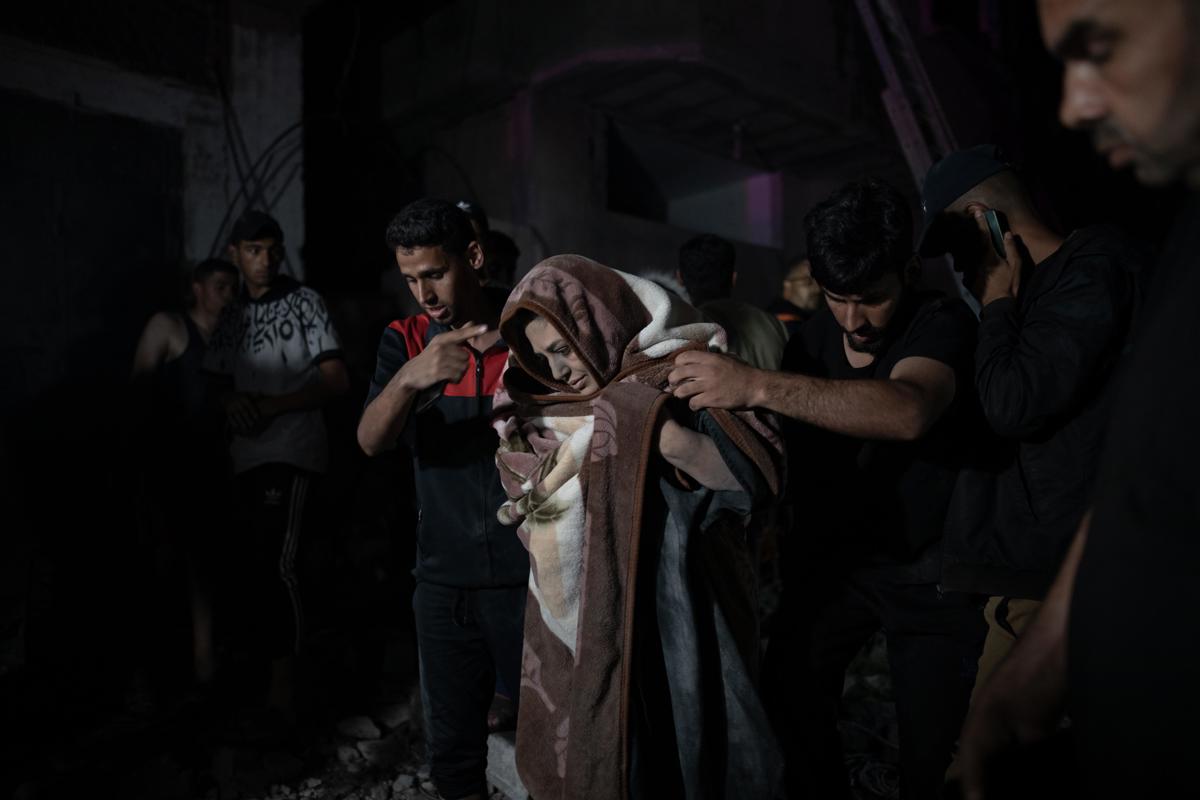 Una mujer es rescatada de los escombros de un edificio derruido tras un bombardeo israelí en Gaza. EFE/EPA/HAITHAM IMAD