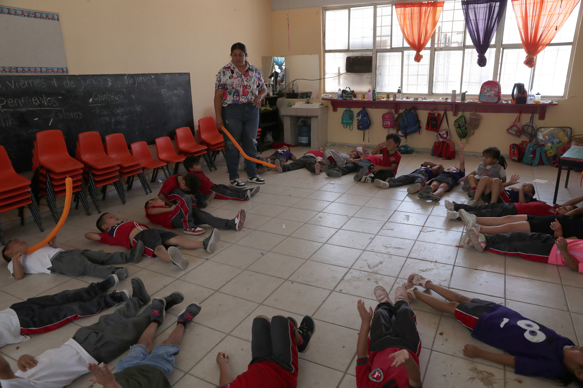 Estudiantes toman un descanso debido a las altas temperaturas este jueves en Ciudad Juárez (México). EFE/ Luis Torres