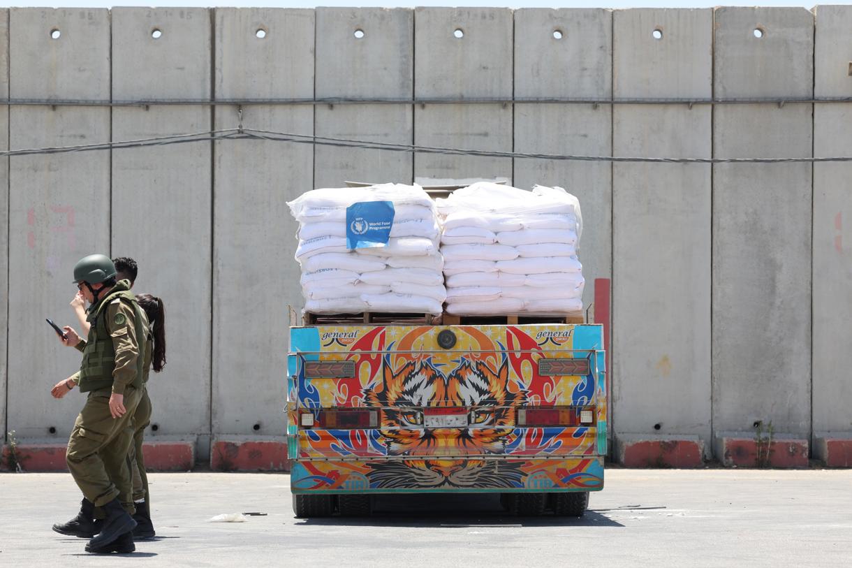 Imagen de Archivo de unos soldados israelíes al pasar junto a un envío de ayuda en el cruce Kerem Shalom en la valla fronteriza con la Franja de Gaza, sur de Israel.