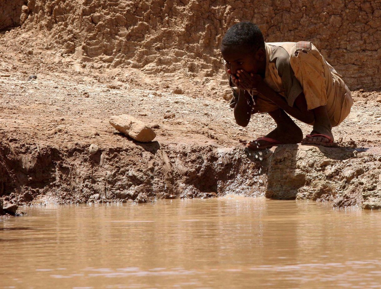 Un niño somalí bebe agua en una presa construida por el hombre en el pueblo de Bur-Dhuxunle al norte de Somalia. Archivo EFE/Thomas Mukoya **Pool