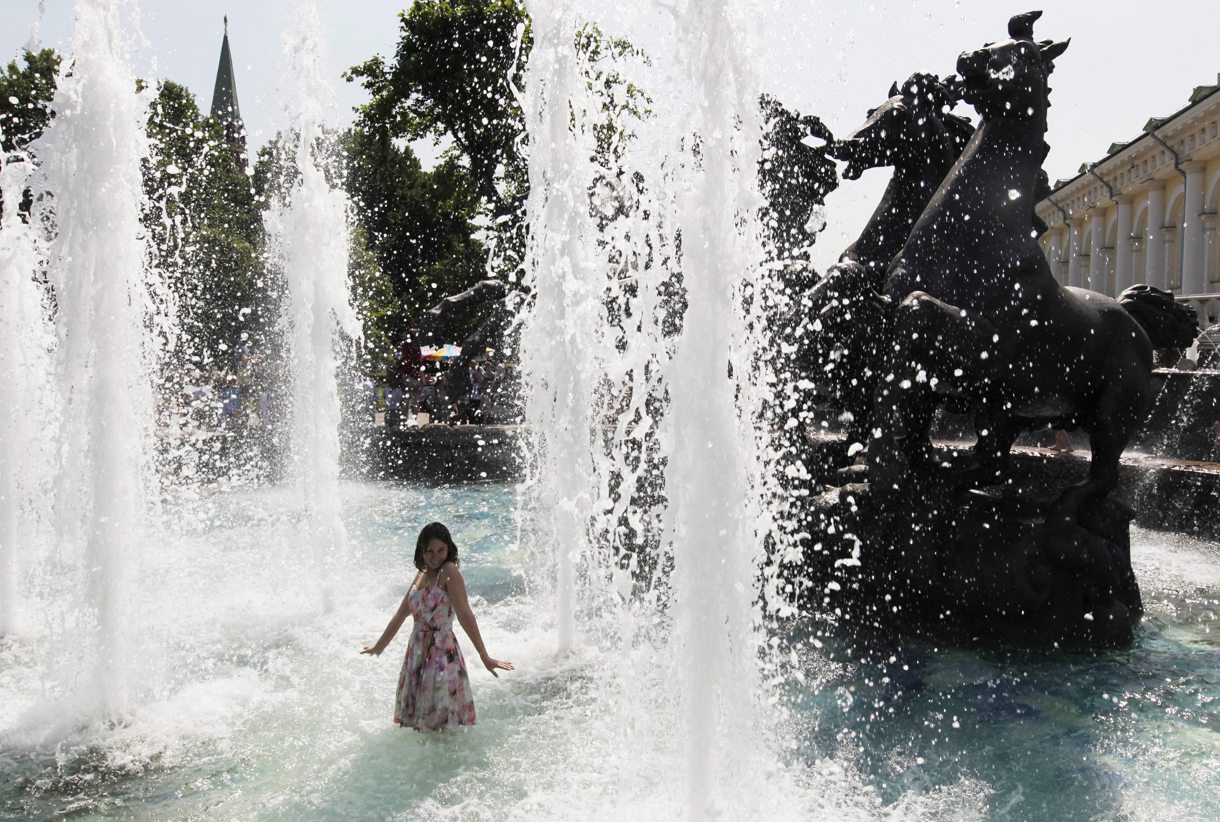 En la imagen de archivo, una joven moscovita se refresca en una fuente para combatir el calor cerca del Kremlin, en Moscú (Rusia). EFE/Yuri Kochetkov