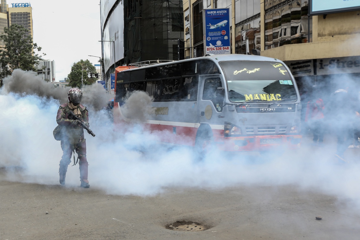 Un oficial de policía keniana envuelto en una nube de gas lacrimógeno durante una de las nuevas protestas organizadas en Nairobi contra el Gobierno del presidente William Ruto, una movilización cuyo origen fue la polémica ley que pretendía subir los impuestos, finalmente retirada. EFE/EPA/Daniel Irungu