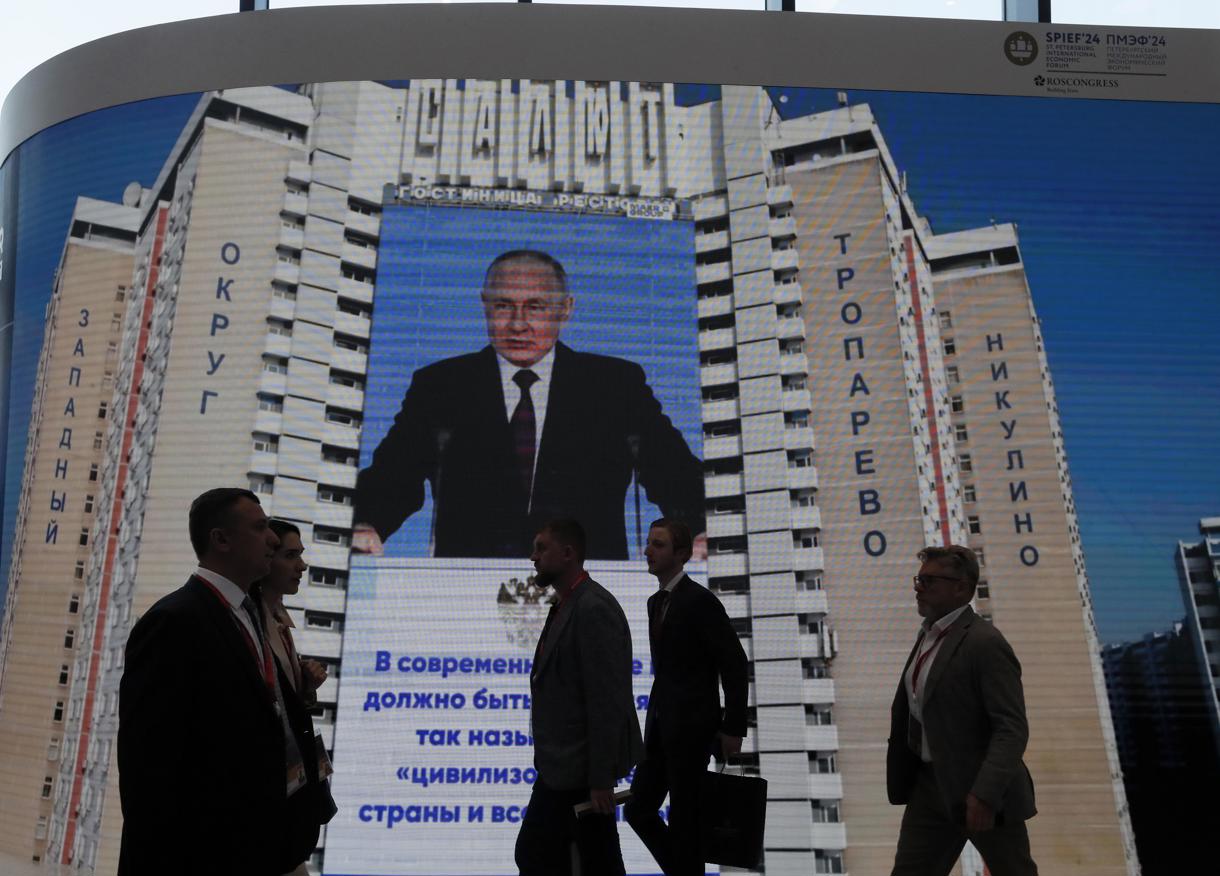 La gente pasa junto a una gran pantalla que muestra una foto del presidente ruso Vladimir Putin en el 27º Foro Económico Internacional de San Petersburgo (SPIEF), en San Petersburgo, Rusia, 05 de junio 2024. (Rusia, San Petersburgo) EFE/EPA/ANATOLY MALTSEV