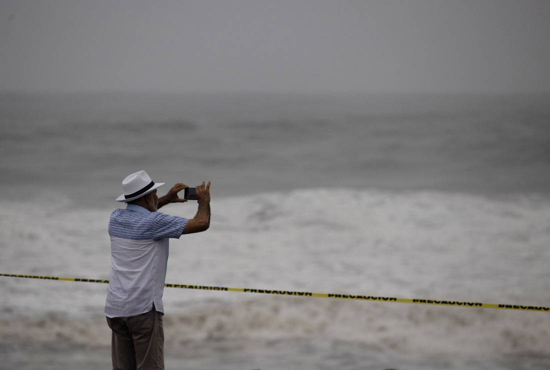 Un hombre observa el fuerte oleaje durante el paso del huracán Beryl, este martes en el malecón de Santo Domingo, República Dominicana. (EFE/ Orlando Barría)