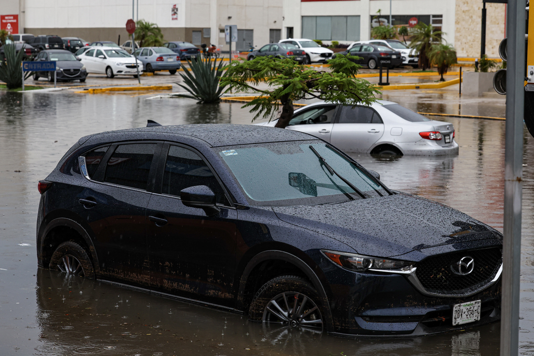 Imagen de archivo de vehículos que circulan por una calle inundada debido a las fuertes lluvias, en Mérida, estado de Yucatán, México. (EFE/Lorenzo Hernández)
