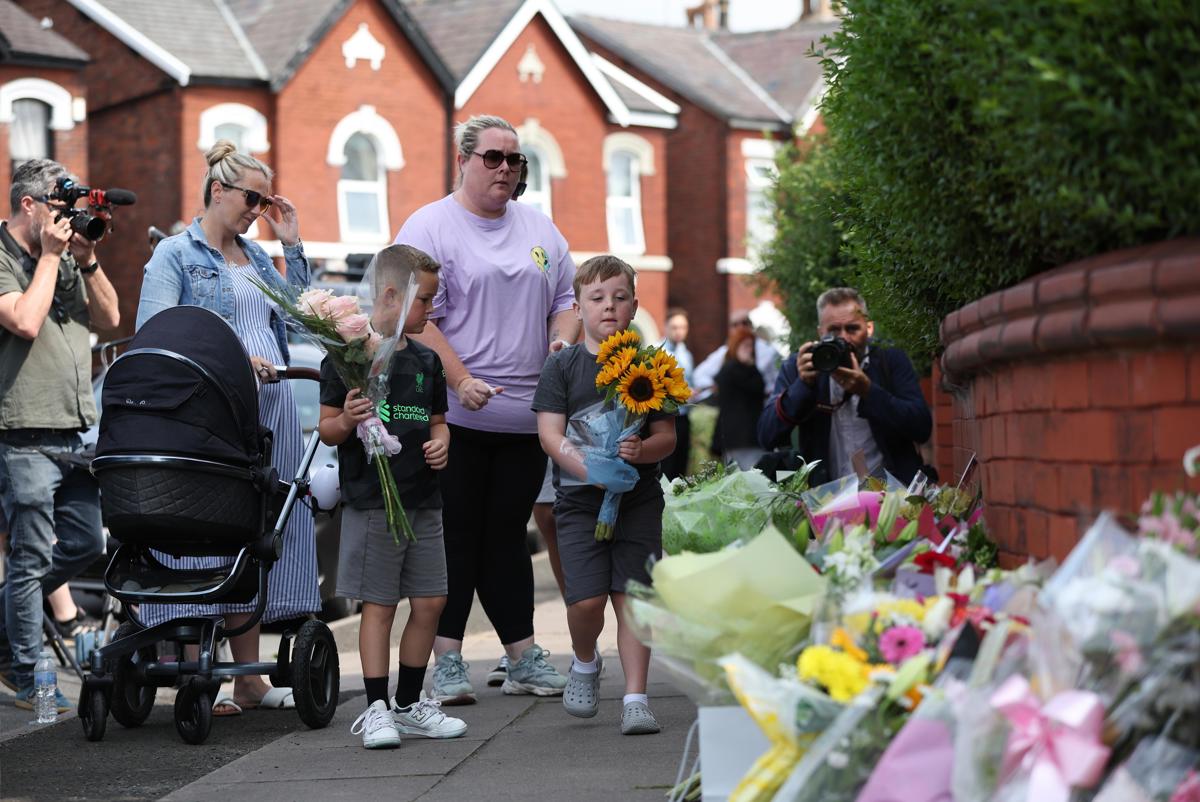 Dos niños depositan flores en el lugar del apuñalamiento múltiple registrado en Southport, Gran Bretaña, el 30 de julio de 2024. (Fotografía Adam Vaughan de la agencia EFE)