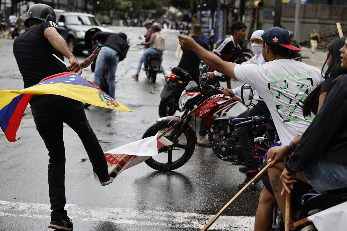 Una persona patea un cartel con la imagen del presidente de Venezuela, Nicolás Maduro, durante una protesta por los resultados de las elecciones presidenciales este lunes, en Caracas (Venezuela). (Fotografía de Henry Chirinos de la agencia EFE)