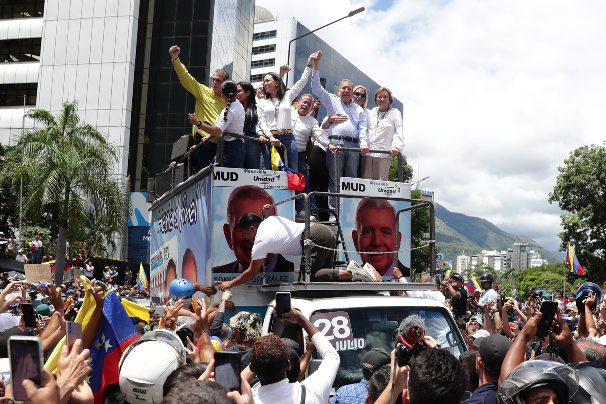 La líder opositora venezolana María Corina Machado (i, arriba) y el candidato a la presidencia de Venezuela Edmundo González Urrutia (d, arriba) participan en una manifestación de apoyo este martes, en Caracas (Venezuela). (Fotografía de Ronald Peña R. de la agencia EFE)