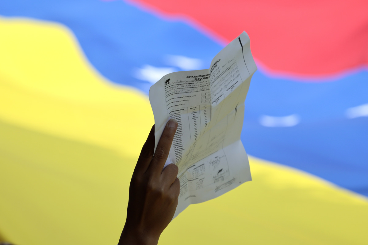 Una persona sostiene una copia de un acta de votación durante una manifestación en rechazo a los resultados del Consejo Nacional Electoral (CNE), en las elecciones presidenciales del domingo que dieron como ganador al presidente de Venezuela Nicolás Maduro, en la Ciudad de México (México). (Fotografía de José Méndez de la agencia EFE)