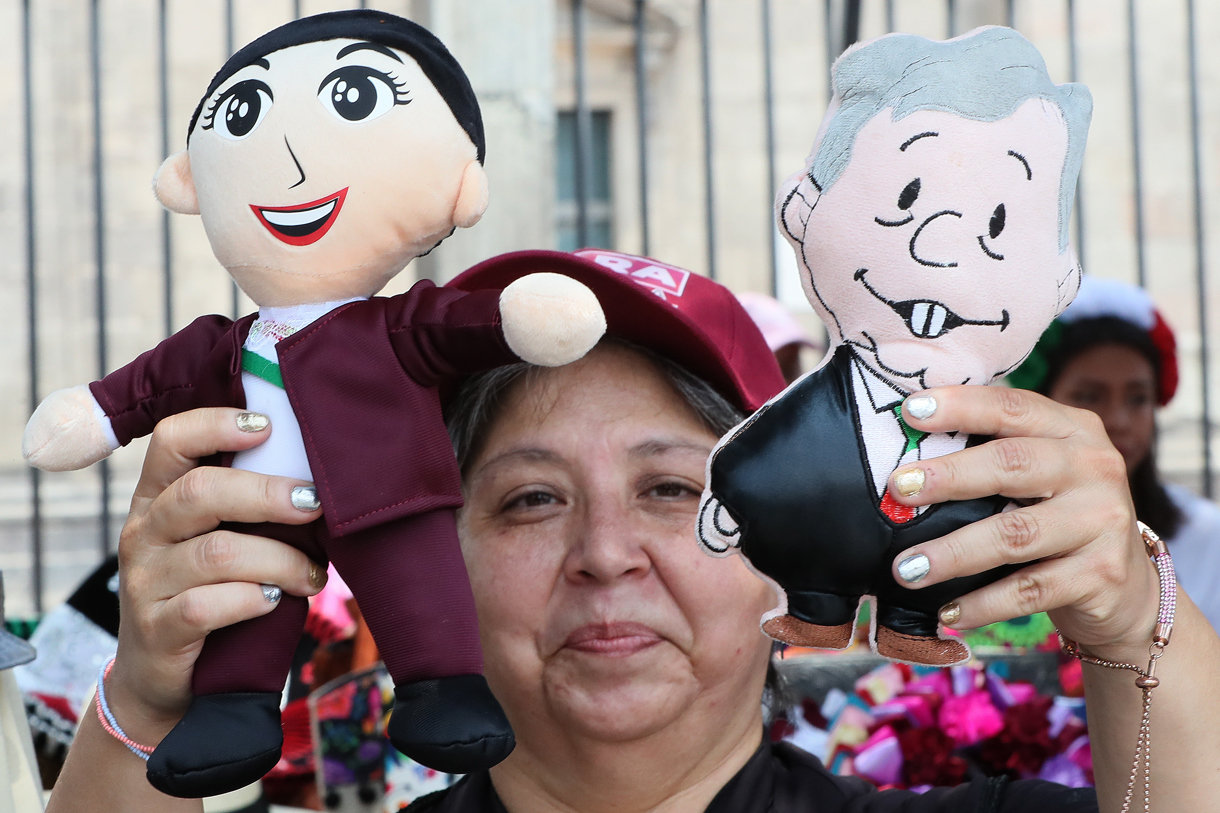 La comerciante en el centro histórico, Victoria Vega, vende muñecos del presidente Andrés Manuel López Obrador este viernes, en el Zócalo de Ciudad de México (México). (Foto de Mario Guzmán de la agencia EFE)