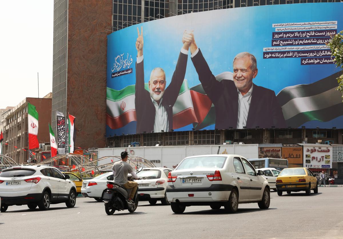 Carteles en Teherán del presidente iraní, Masud Pezeshkian (D), y el fallecido líder de Hamas Ismail Haniyeh (I). (Fotografía de Abedin Taherkenareh de la agencia EFE/EPA)