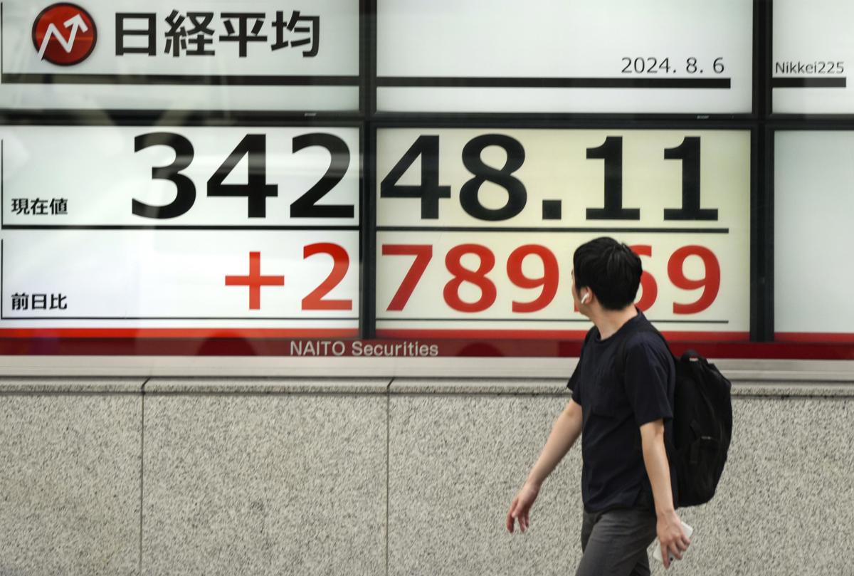 Una persona pasar cerca de un cartel con la valoración de la Bolsa de Japón. (Fotografía de Kimimasa Mayama de la agencia EFE/EPA)