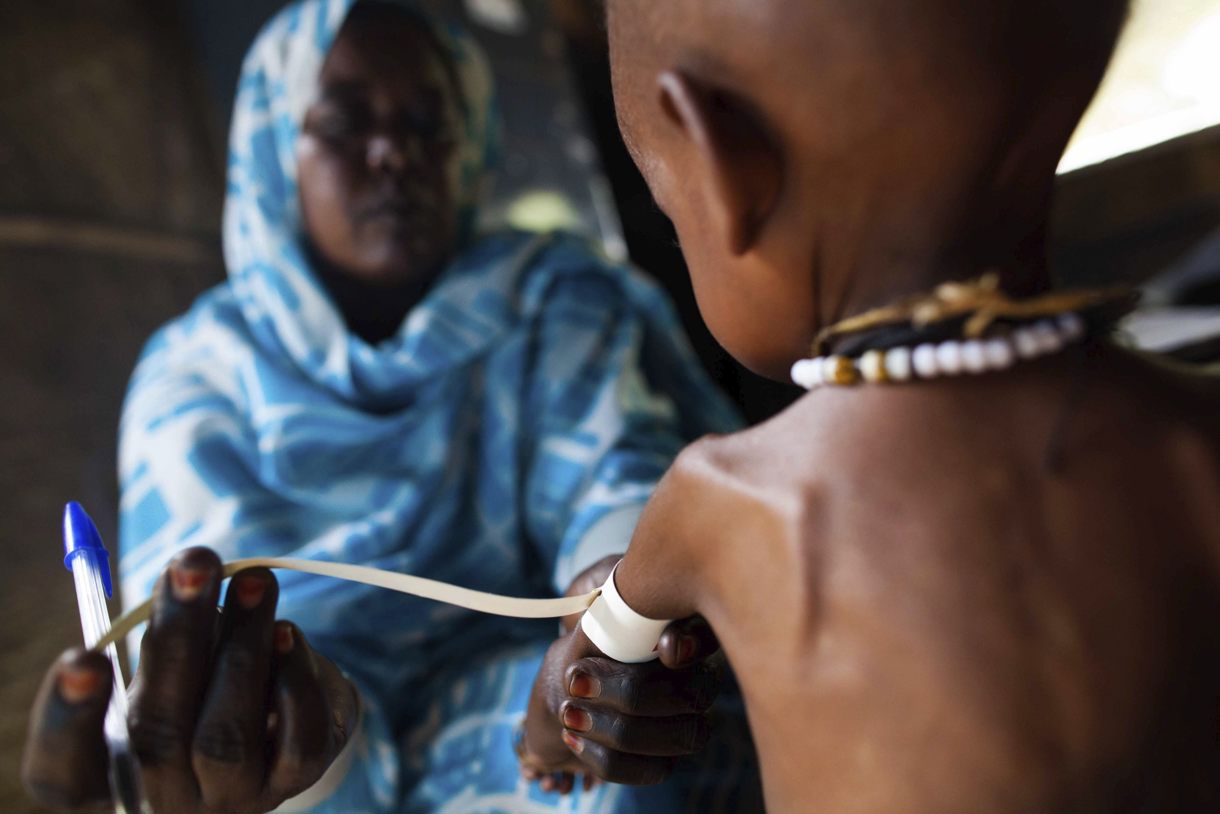 Una enfermera que mide el grosor del brazo de un niño con malnutrición en una clínica de la ONG Kuwait Patients Helping Fund, en la región sudanesa de Darfur. (Fotografía de archivo de Albert González Farran de la agencia EFE)