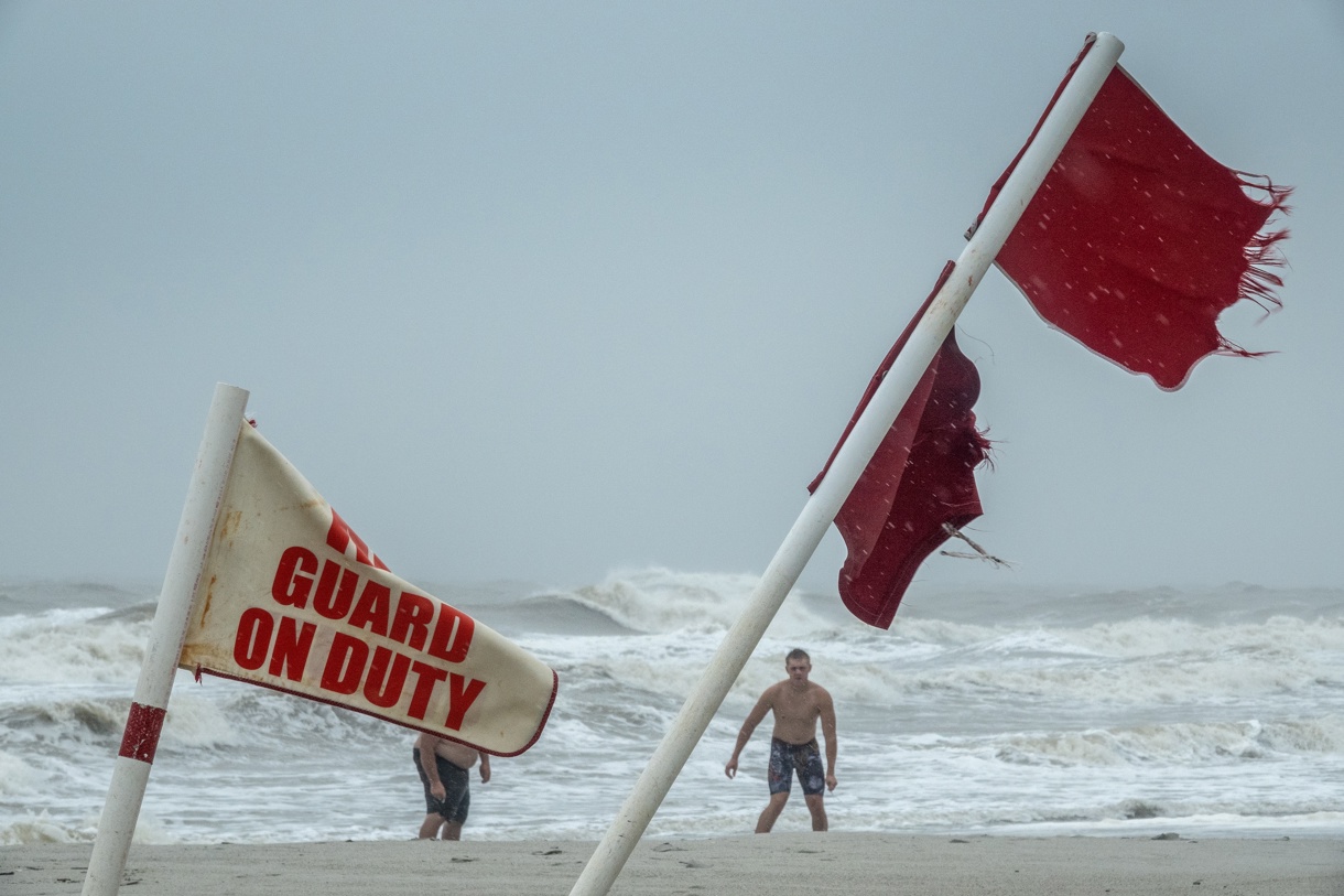 Banderas rojas mientras la gente camina por la playa durante la lluvia que genera la tormenta tropical Debby en Myrtle Beach, Carolina del Sur, Estados Unidos, el 7 de agosto de 2024. (Foto de Cristóbal Herrera-Ulashkevich de la agencia EFE)