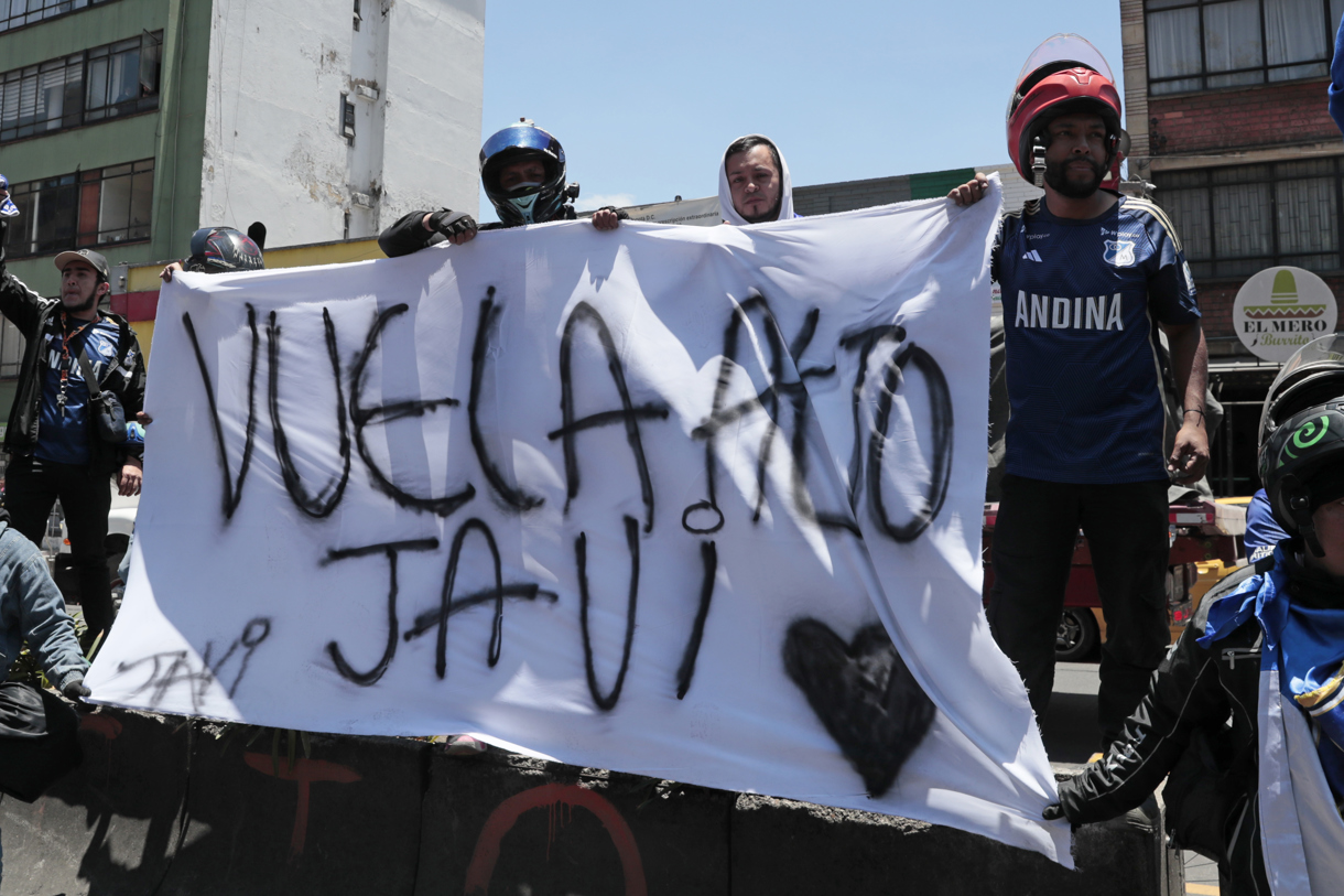 Integrantes de la barra Comandos Azules del equipo colombiano Millonarios alientan afuera del hospital San Ignacio para despedir a Javier Acosta este viernes, en Bogotá (Colombia). (Foto de Carlos Ortega de la agencia EFE)