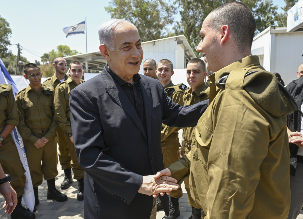 El primer ministro de Israel, Benjamín Netanyahu (c), visita en la base de Tel Hashomer, cerca de Tel Aviv, a los reclutas del Cuerpo de Blindados y el de Ingeniería de Combate del ejército israelí. (Foto de la Oficina del primer ministro Israelí cedida a la agencia EFE)