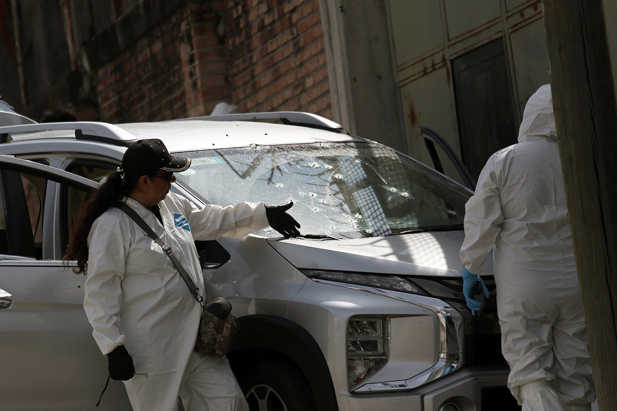 Peritos forenses trabajan en la zona donde fueron encontrados dos cuerpos. (Foto de José Luis de la Cruz de la agencia EFE)