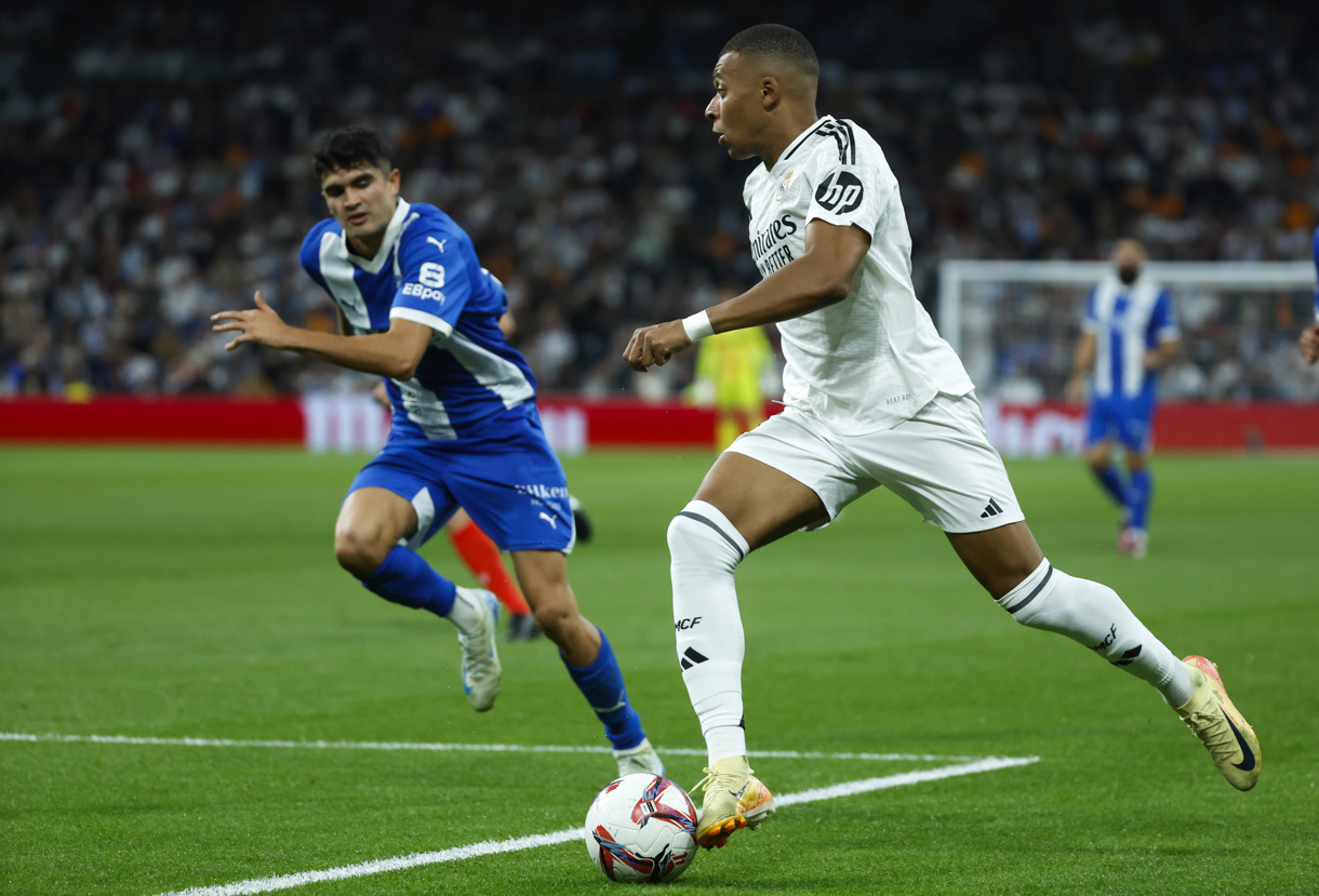 El delantero francés del Real Madrid, Kylian Mbappé (d), conduce el balón ante el defensa del Alavés durante el encuentro correspondiente a la séptima jornada de Laliga EA Sportsen el estadio Santiago Bernabéu, en Madrid. (Foto de Juanjo Martín de la agencia EFE)