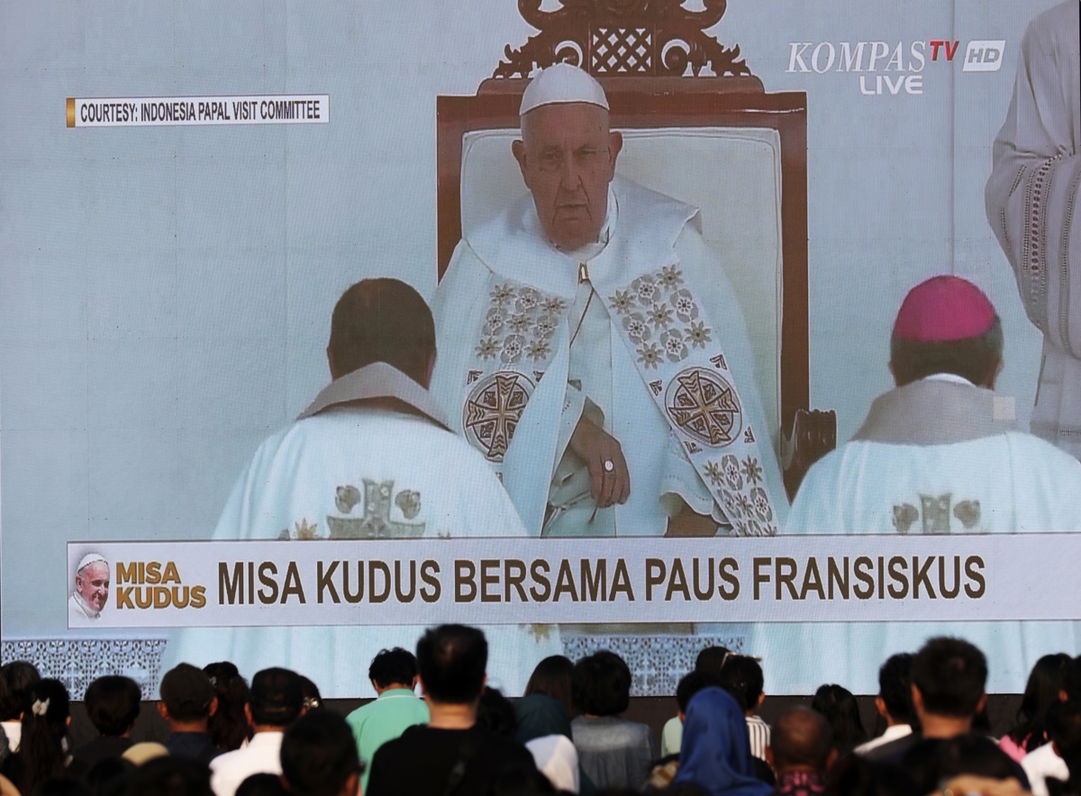 Personas siguen en una pantalla gigante la misa en vivo del papa Francisco en el estadio Gelora Bung Karno en Yakarta, el 05 de septiembre de 2024. (Foto Bgus Indahono de la agencia EFE/EPA)