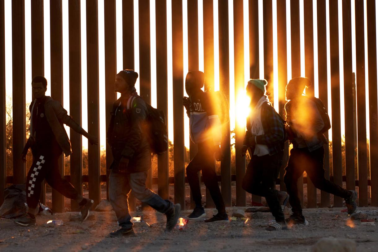 Fotografía de archivo de migrantes que caminan junto al muro en la frontera de EUA y México en Lukeville, Arizona, EUA. (Foto de Allison Dinner de la agencia EFE)